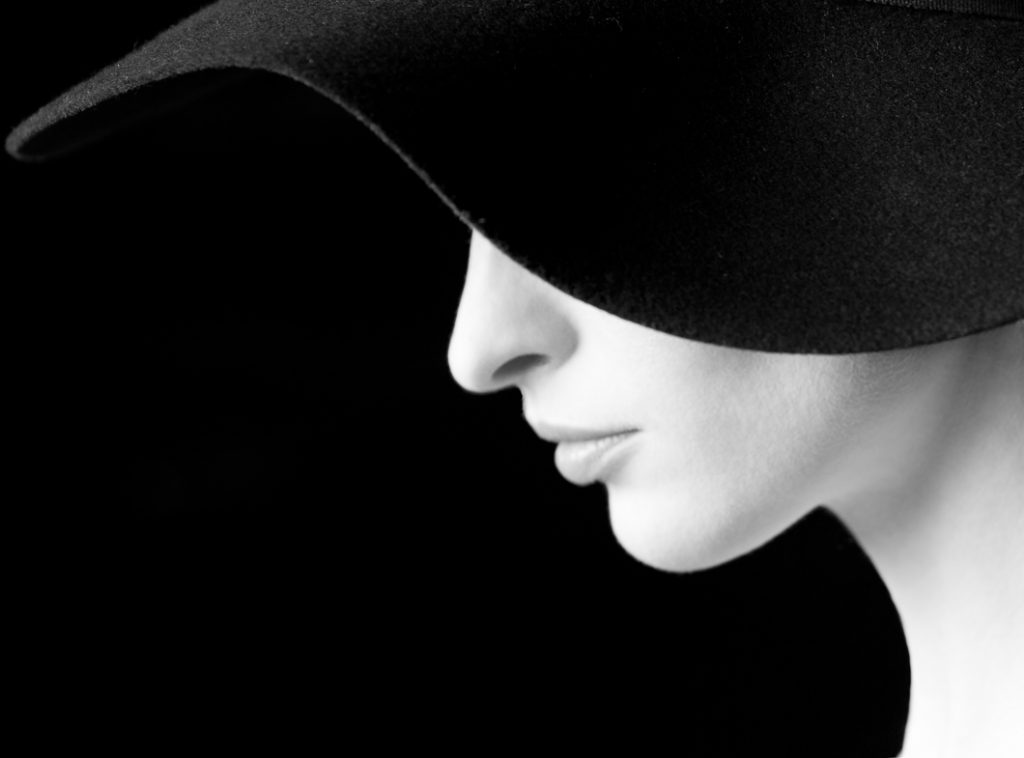 Portrait Photography - Portrait Photographer - monochorme profile image of the models face and hat making a curves shape
