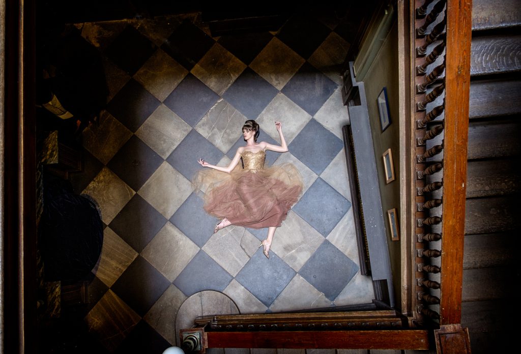 fashion photographer - fashion photography - colour image from fashion shoot a wentworth woodhouse featuring model lying on the floor in a gold and brown dress shot from above, she looking like she has fall to that place on the floor