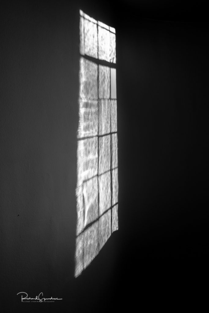 shadows of a window playing on the opposite wall in a corridor