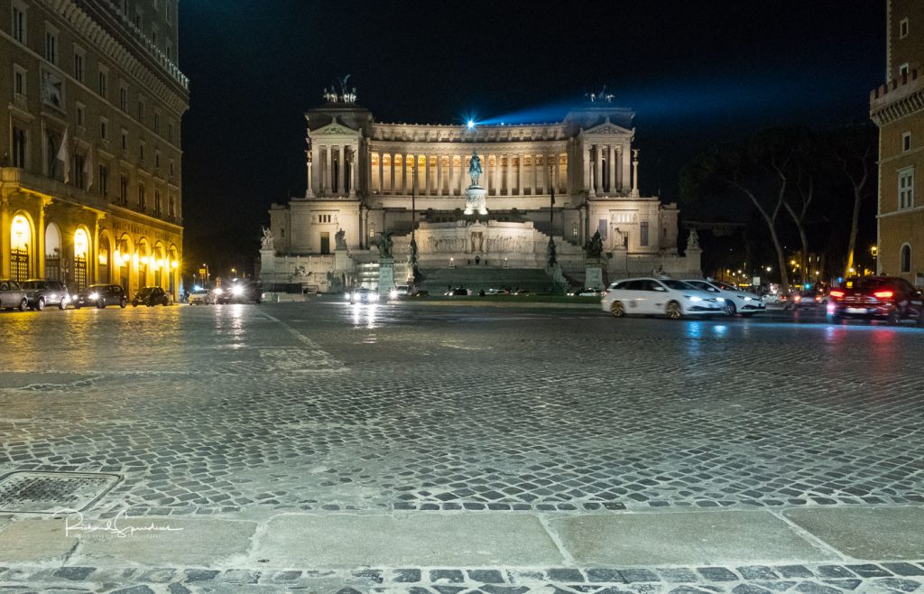 travel photography - travel photograher - colour image from a visit to rome this one across the piazza venezia roundabout showing the impressive Monumento Nazionale building lit up by the buildings lights photographing rome at night