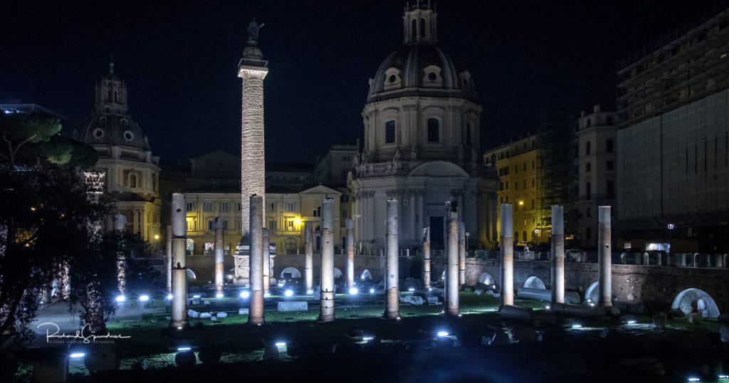 travel photography - travel photograher - colour image from a visit to rome this one shot at night shows a set of columns illuminated by the flood lights surrounded be the modern building of rome