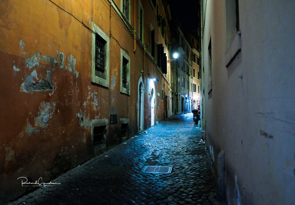 travel photography - travel photographer - image showing interesting colours of the walls in the side streets of rome shot at night and illuminated be the street lamps