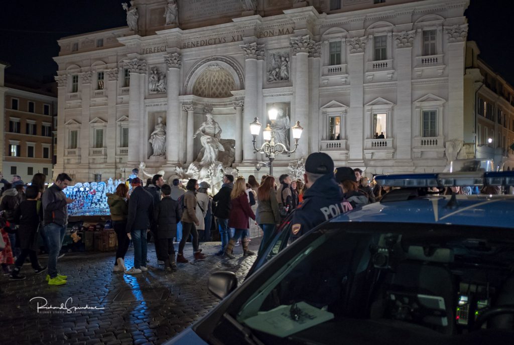 travel photography - travel photogarpher - image from the trevi fountain square shoot around 20:00 still lots of tourists stood in front of the fountain showing the crowds and the police keeping a watchful presence