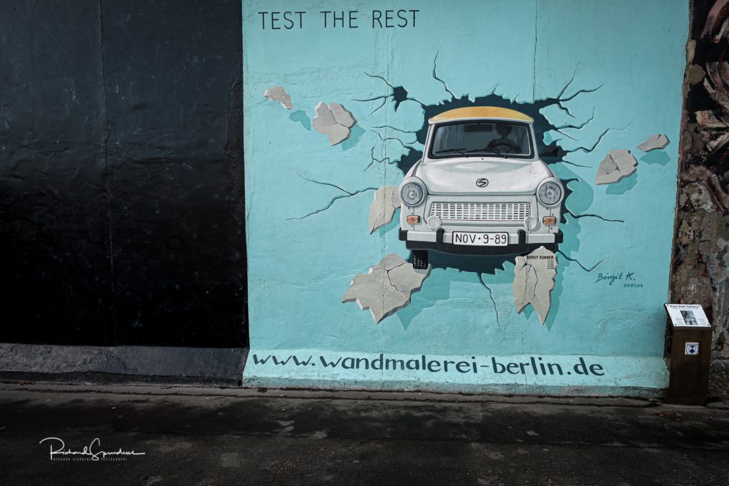 street photography - street photographer - image showing the wall mural entitled breaking through - berlin wall