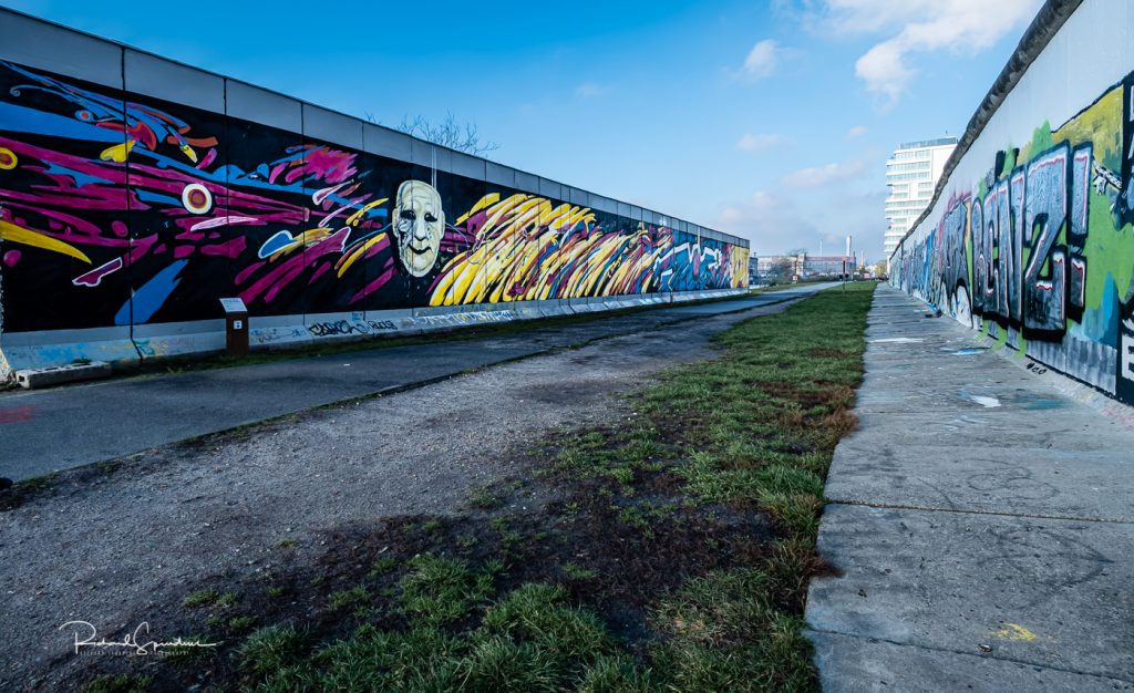 street photography - street photographer - image showing the wall murals - berlin wall