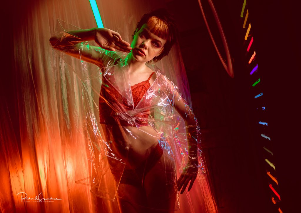 Fashion photographer - Fashion photography - colour image from electic dreams model wears a clear plasticmack and shor using neon lights - highlights 2019