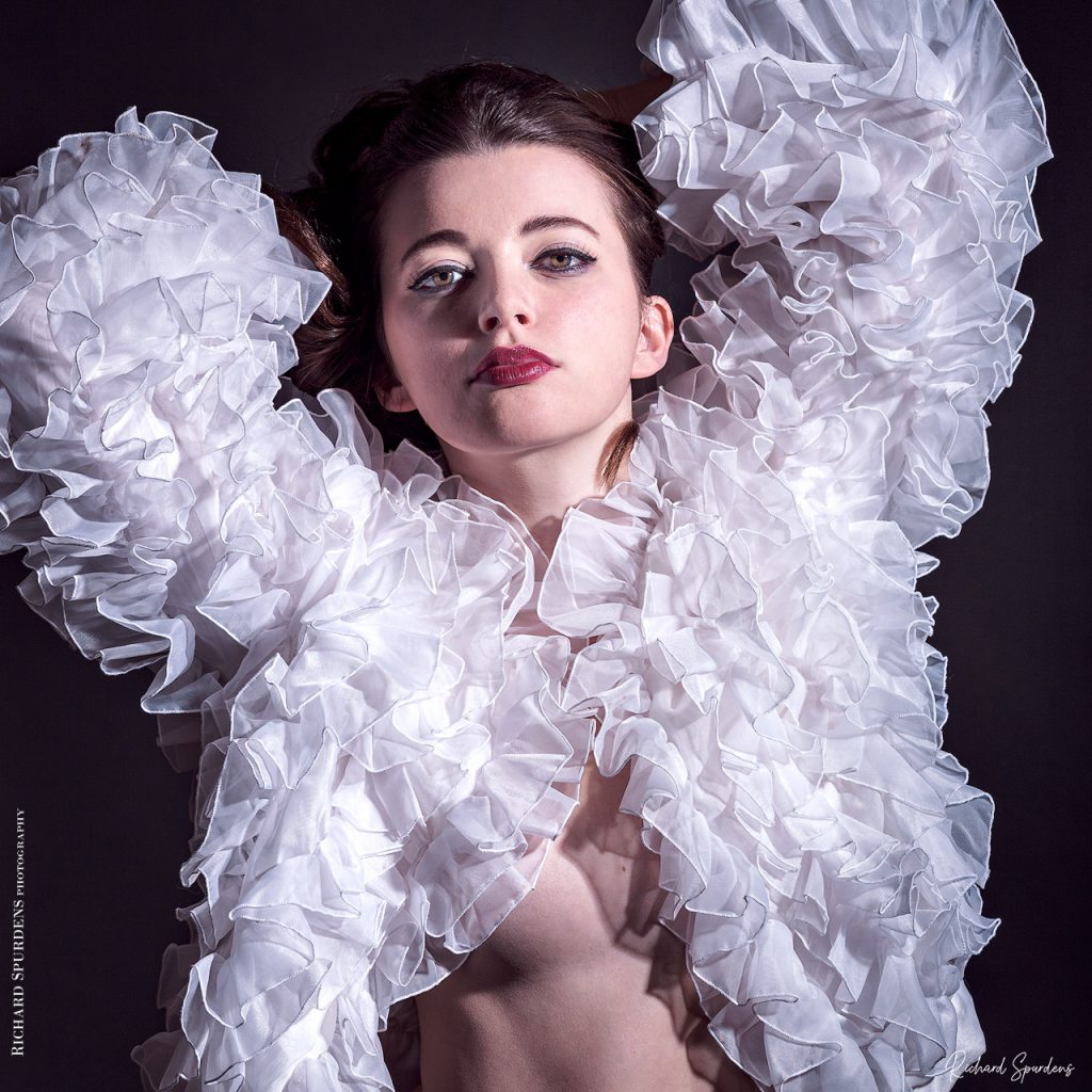Fashion Photography - Fashion Photographer - featuring a model wearing a white ruffled scalloped jacket using a single light setup