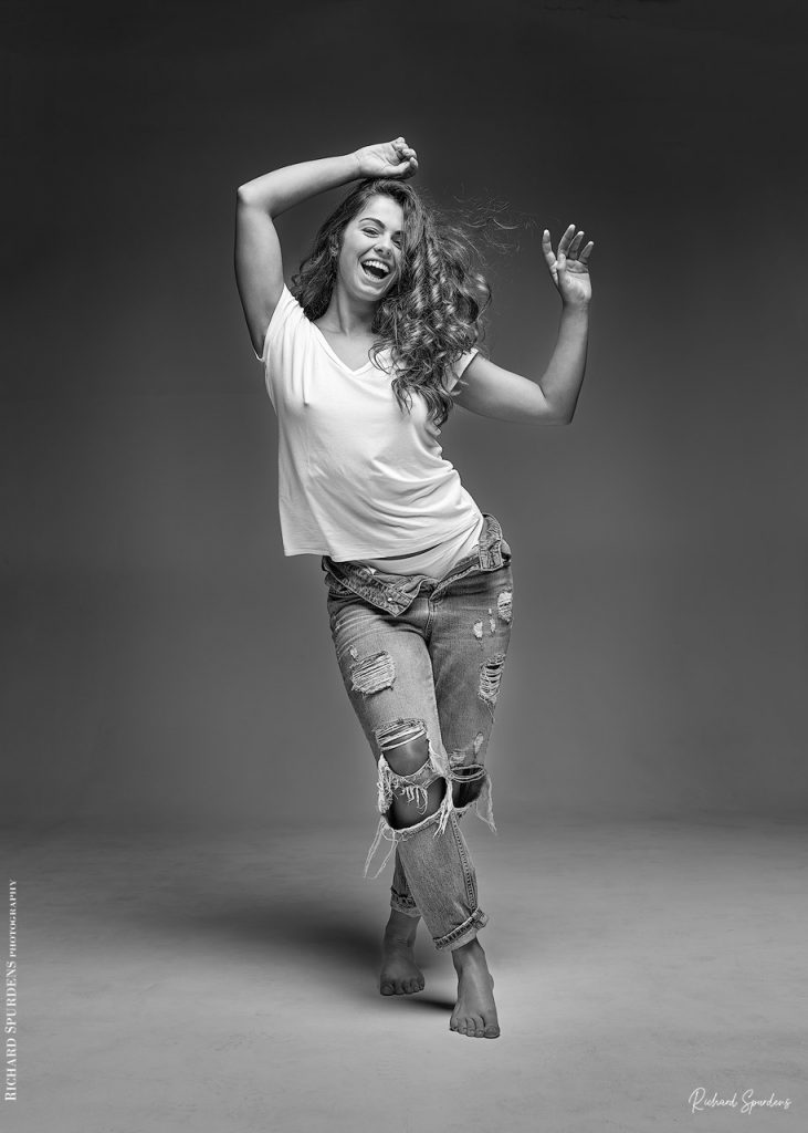 Fashion Photography - Fashion Photographer - model wearing torn jeans standing and holding her arms above her shoulders