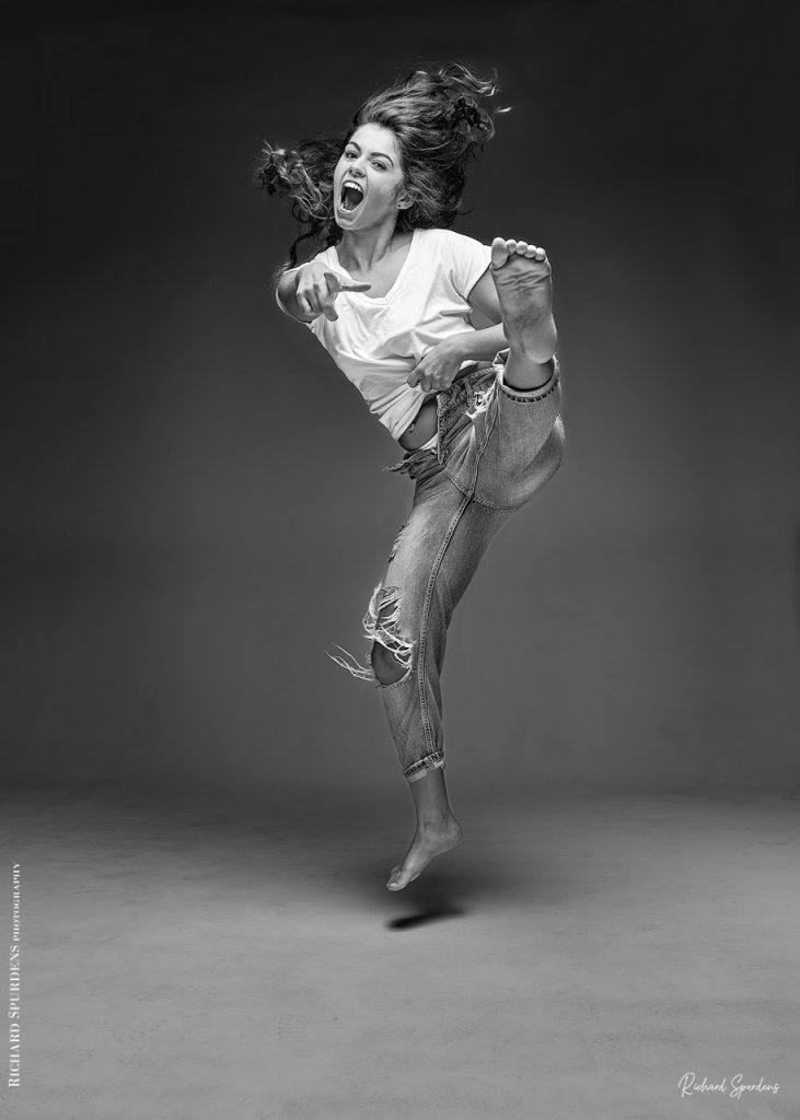 Fashion Photography - Fashion Photographer -model wearing torn jeans doing a leg kick towards the camera