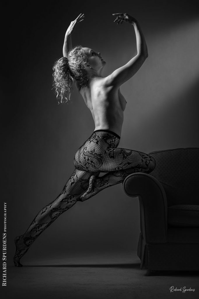 Fine Art Nude Photography - Nude Photography - Fine Art Nude Photographer - Fine Art Nude - Ivory flame wearing paisley patterned tights and making strong female form shapes against the edge of a settee