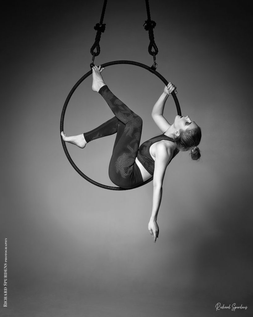 Aerial Arts photographer - Aerial hoop photographer - Aerial Arts photography - Aerial hoop photography - aerialist sitting inside her aerial hoop holding position with feet and back