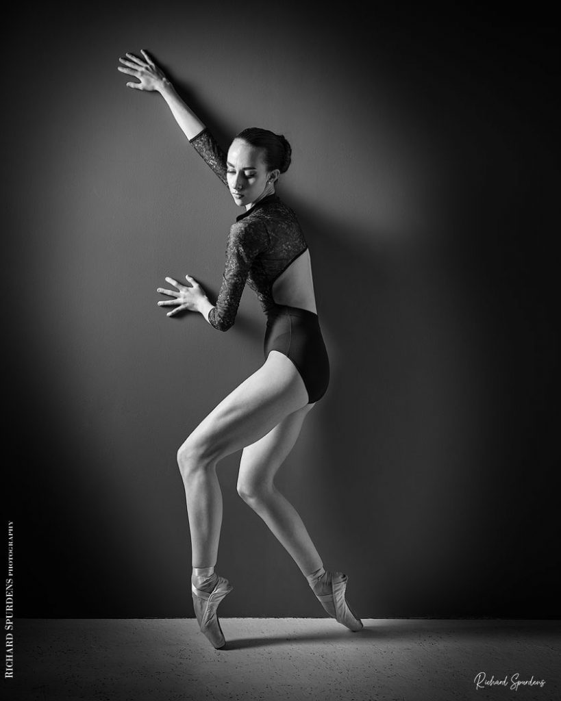 Dance Photographer - Dance photography - dancer making shapes against the wall lit from the side