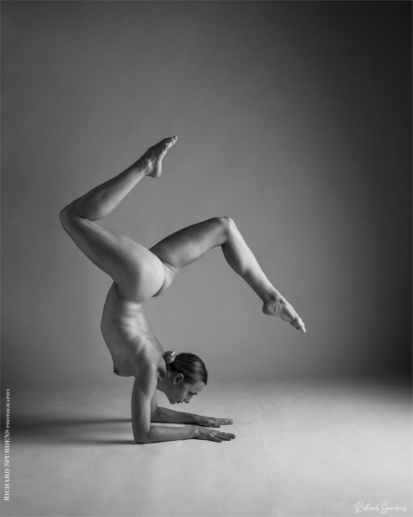 Artisitic nude photography - Artistic nude Photographer - dancer performing a handstand with arms flat on the floor and each leg angled to match each other