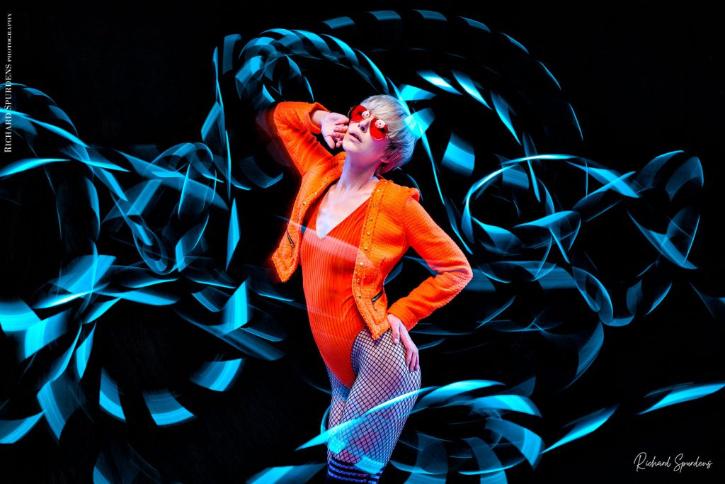 Light painting Photography - Fashion Photographer - colour image using a blue light painting wand creating blue swirls around the model